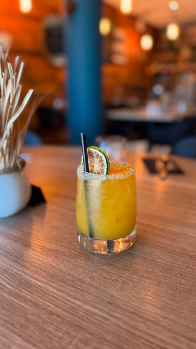 Cocktail glacé au verre givré, tranches d'agrumes séchées, en salle