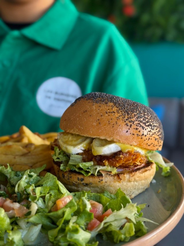 Burger, salade et frites en gros plan, portés à hauteur de table