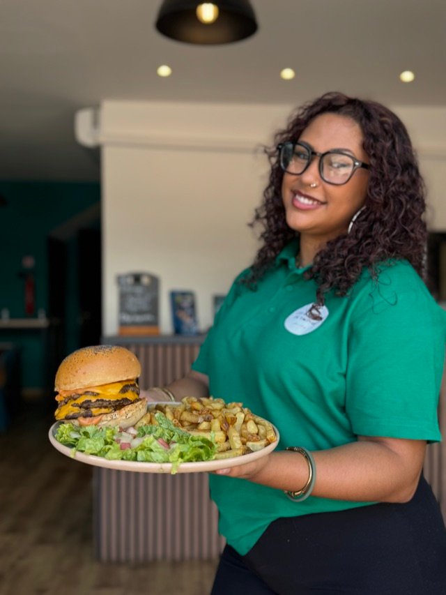 Membre de l'équipe en polo vert présentant une assiette