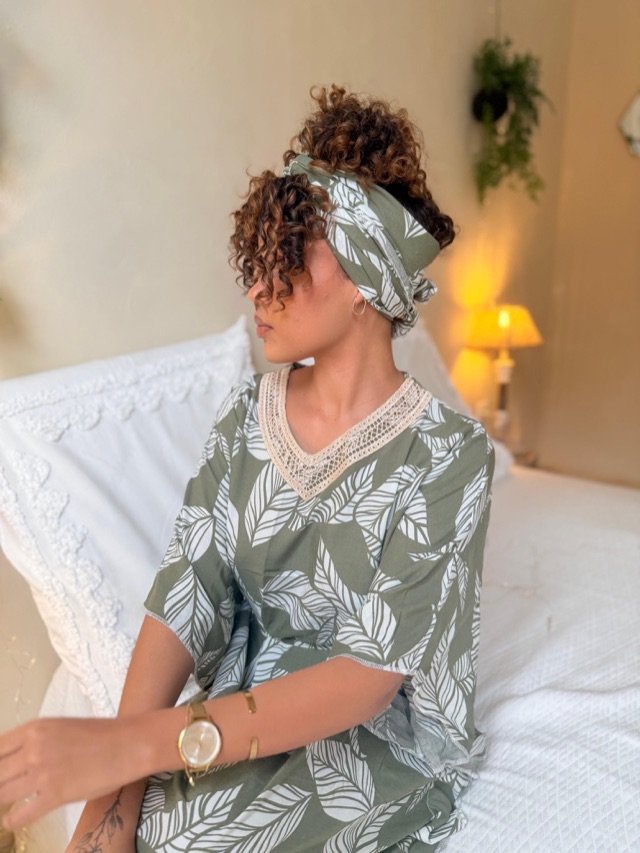 Ensemble kaki à feuillages blancs, col en dentelle et turban assorti, assise sur un lit